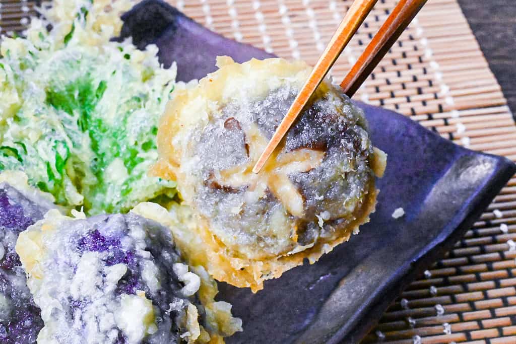 Tempura shiitake mushroom held with chopsticks