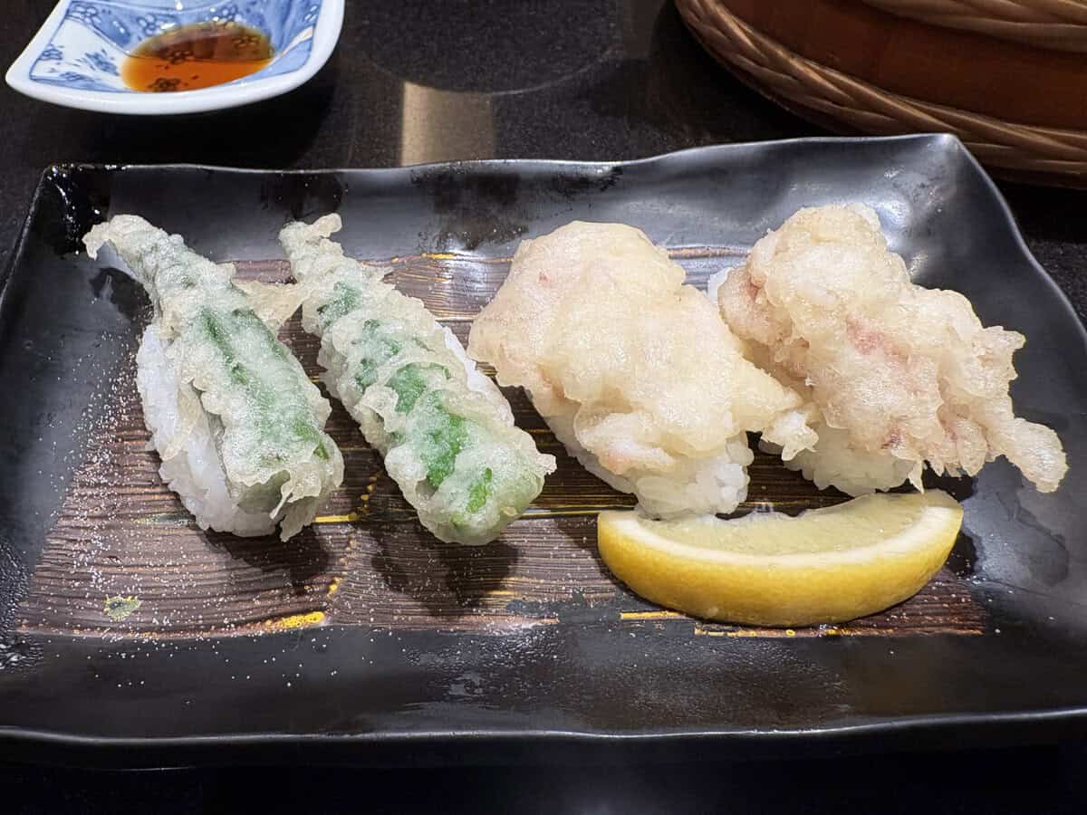 tempura vegetables on top of nigiri sushi