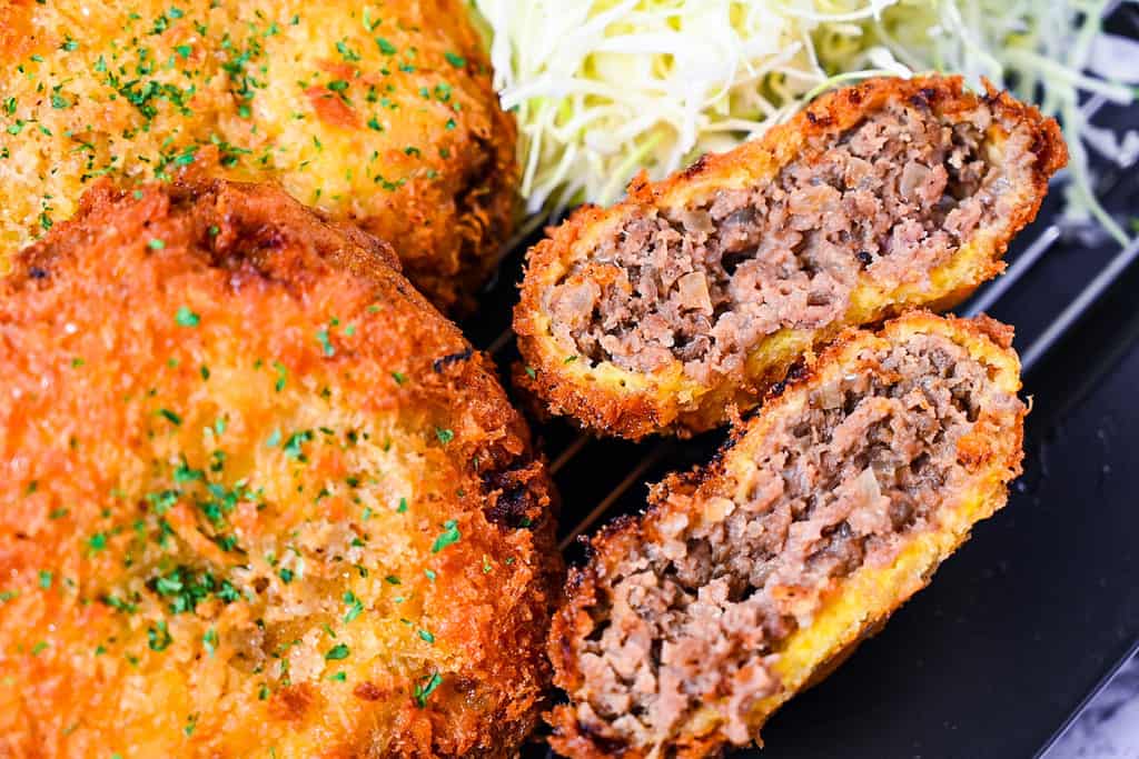 Menchi Katsu Japanese ground meat cutlet drizzled with homemade sauce and shredded cabbage