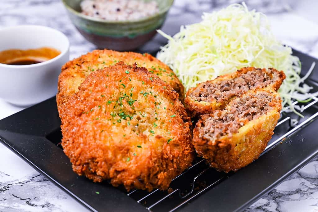 Menchi Katsu Japanese ground meat cutlet drizzled with homemade sauce and shredded cabbage