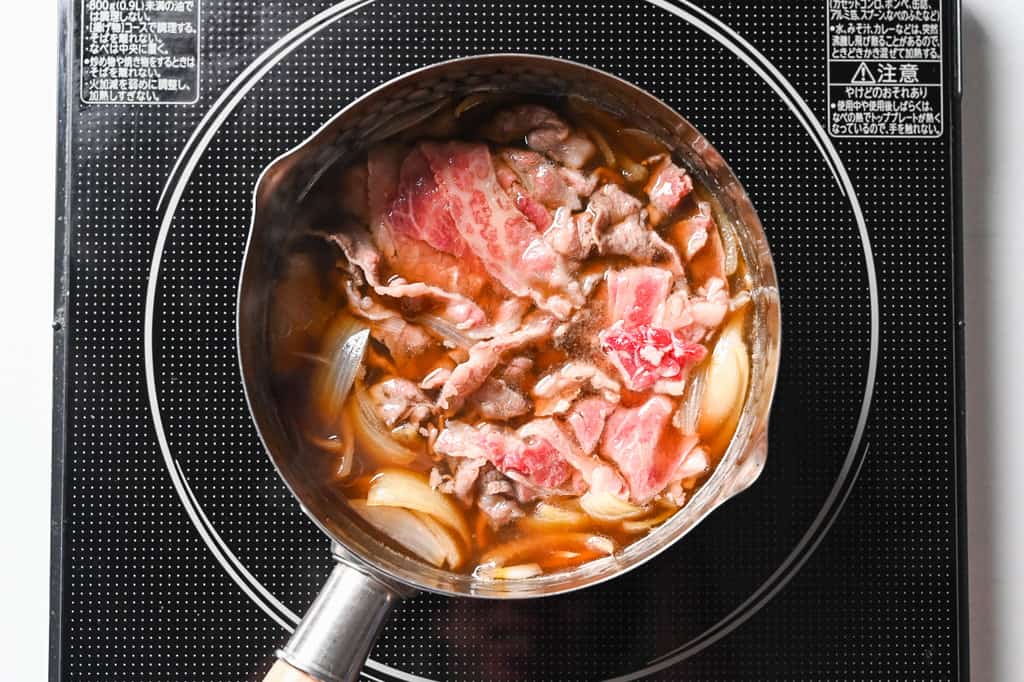 Simmering beef and onion in gyudon broth