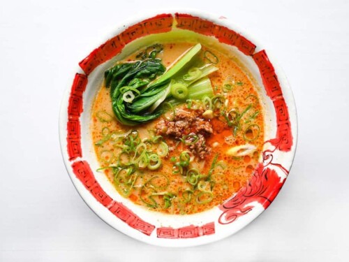 topping tantanmen with pak choi and spring onions