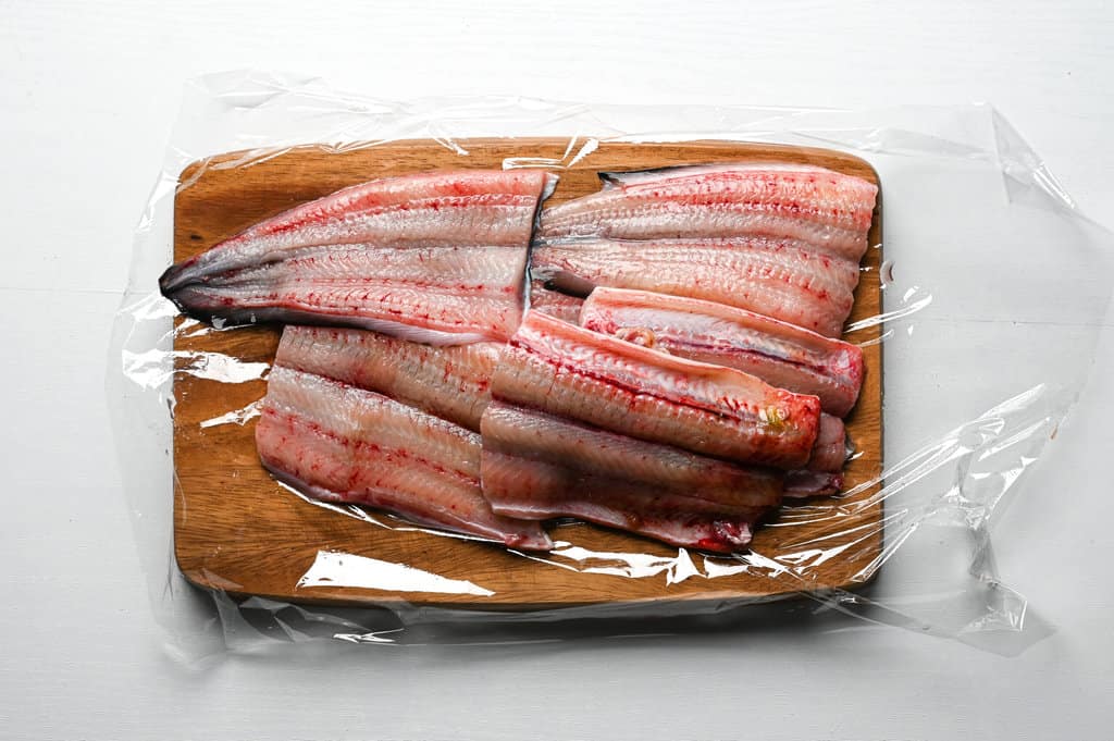 eels being cut on a plastic wrap