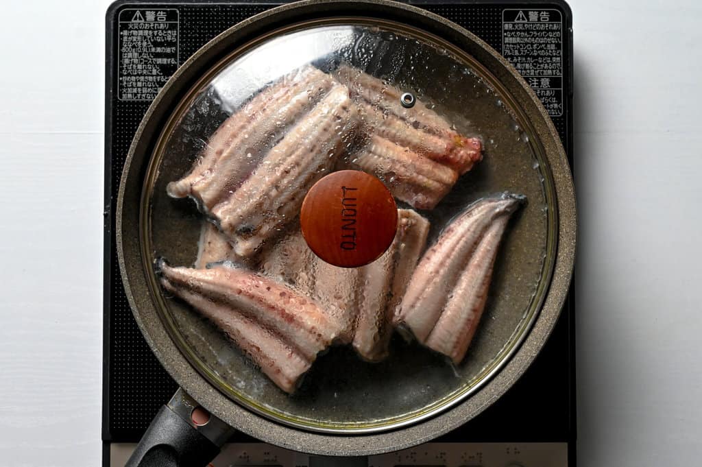 steaming eels in a frying pan