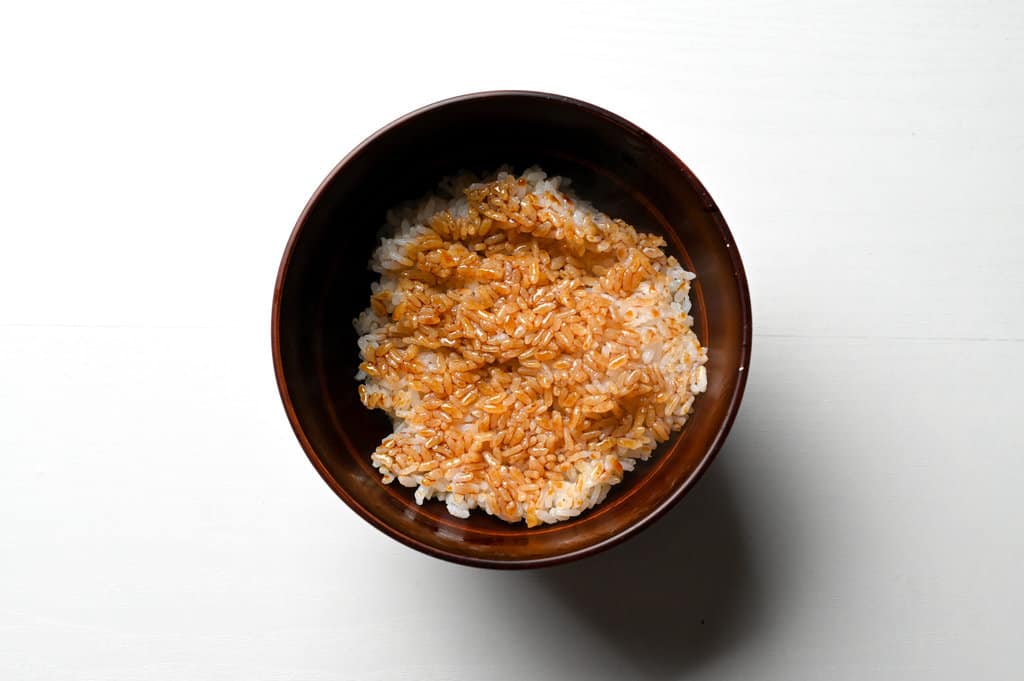 applying unagi sauce on unadon rice