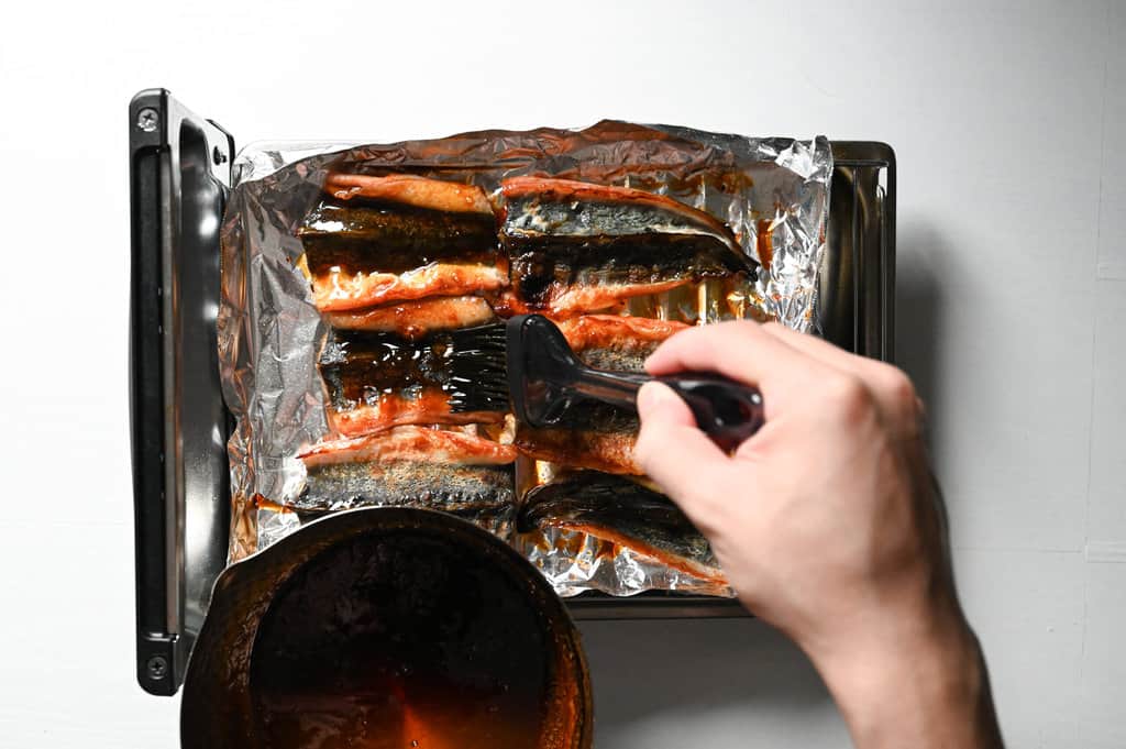 Applying unagi sauce on eels on skin side