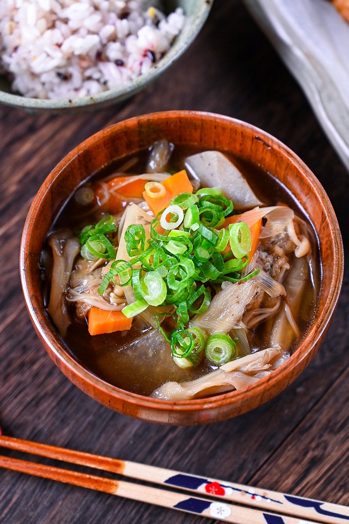 Japanese vegetable soup "kenchin jiru" served in a wooden bowl and topped with chopped spring onions