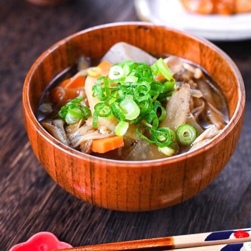 Japanese vegetable soup "kenchin jiru" served in a wooden bowl and topped with chopped spring onions