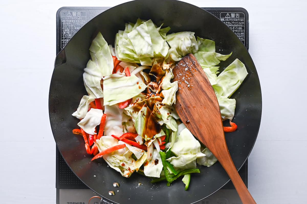 Stir frying vegetables in wok and adding sauce