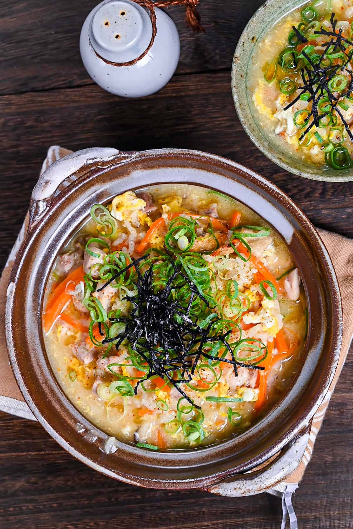 Japanese chicken rice soup (zosui / ojiya) in a brown nabe topped with kizami nori