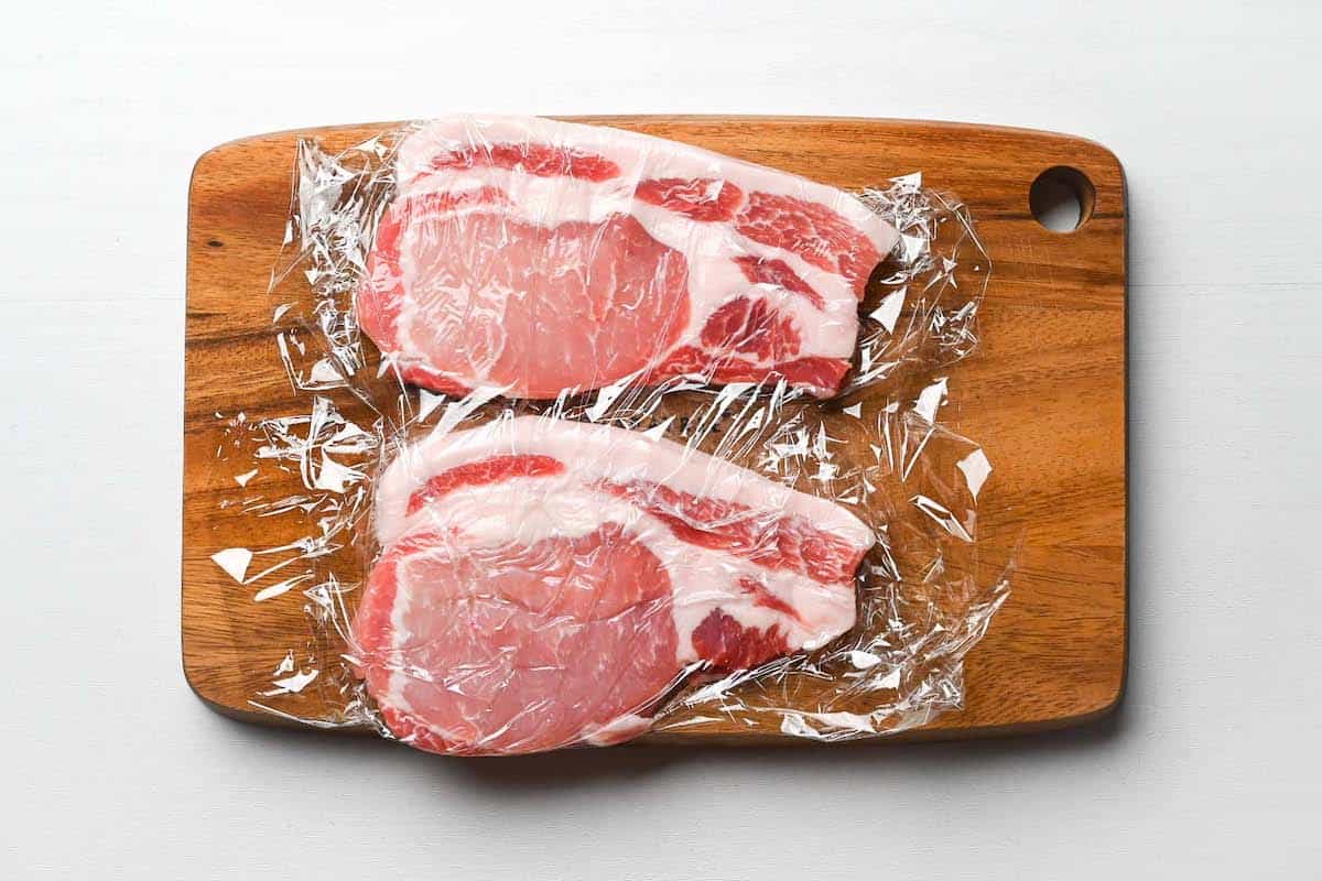 pounded pork chops on a chopping board