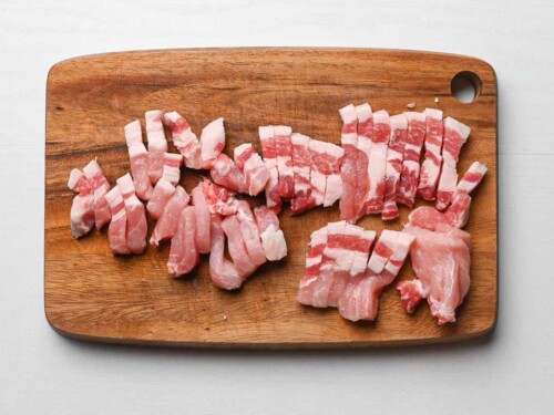 pork chops cut into strips on wooden chopping board