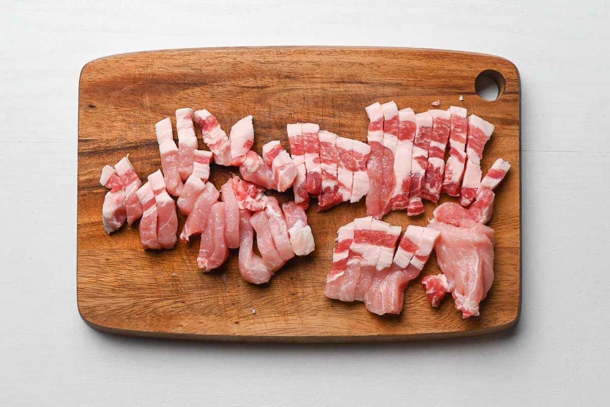 pork chops cut into strips on wooden chopping board