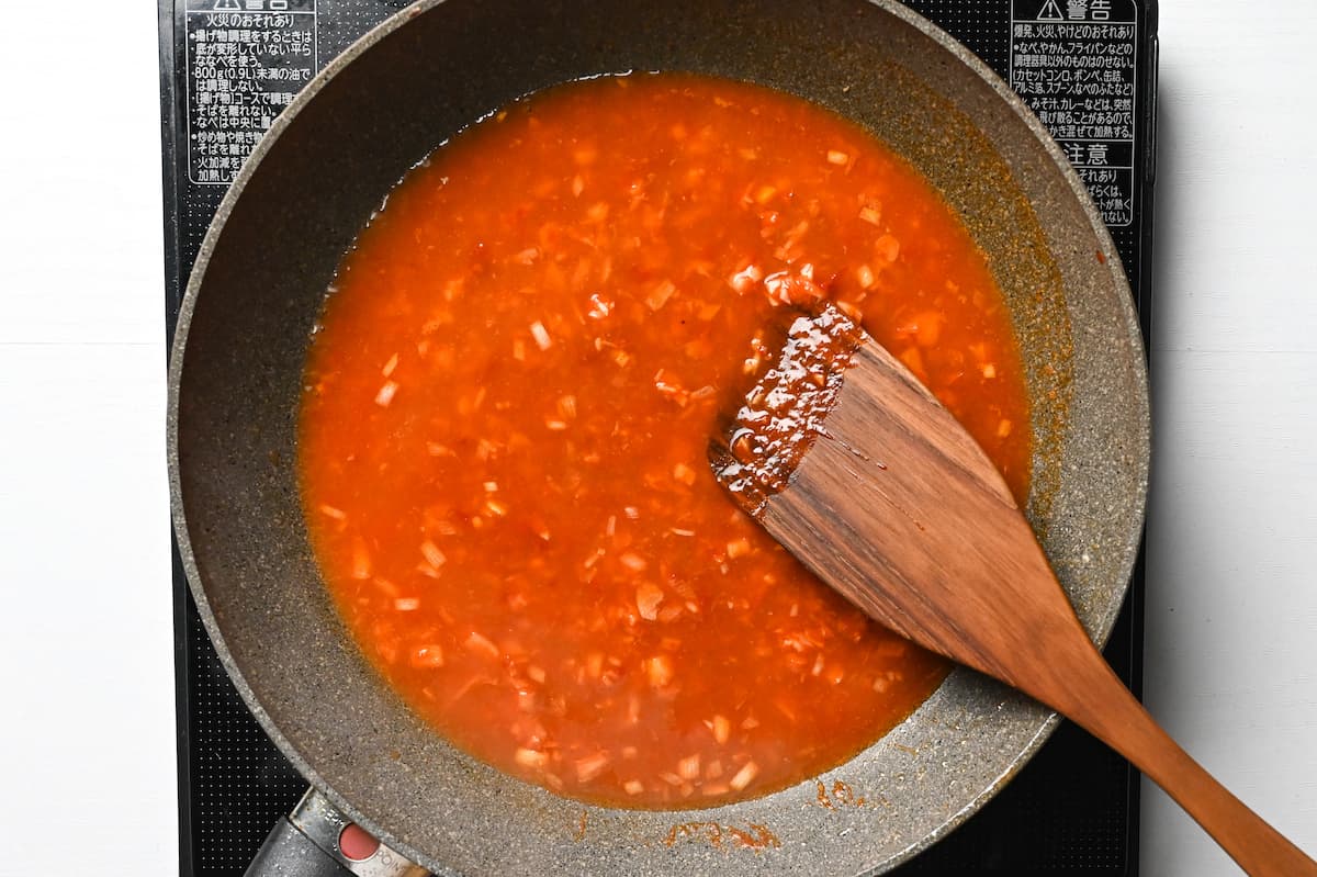 adding chicken stock to the pan