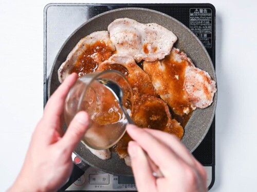 pouring shogayaki sauce over cooked pork