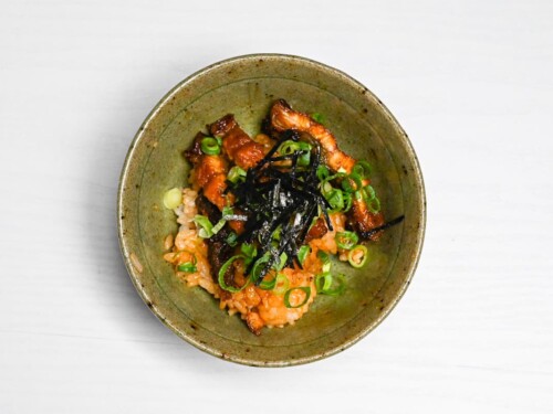 hitsumabushi in a rice bowl topped with chopped spring onions and kizami nori