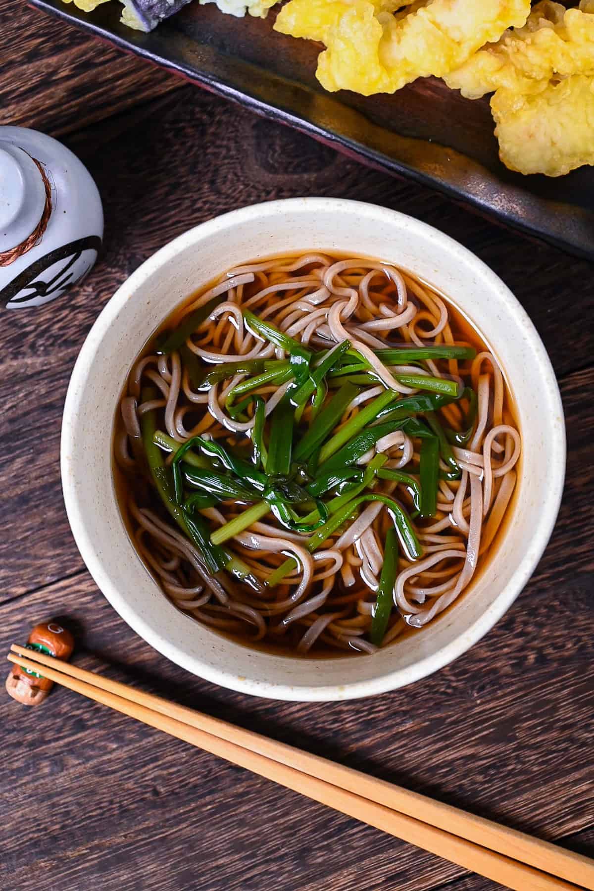 kake soba soup in a white bowl topped with spring onion