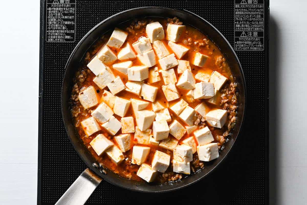 adding chicken stock and tofu