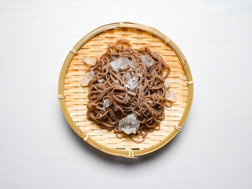 chilling cooked soba noodles with ice on a bamboo tray