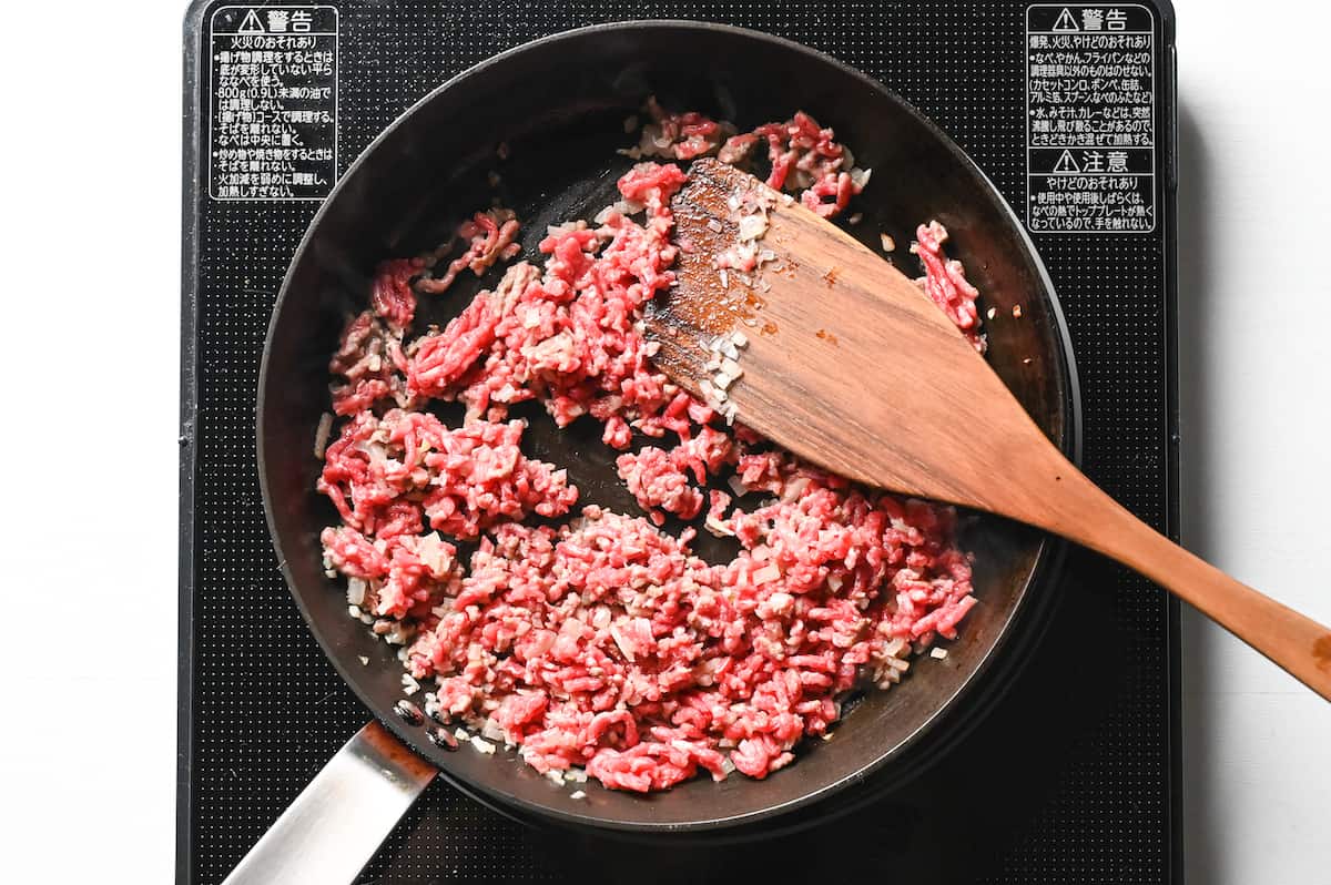 adding ground beef to a frying pan