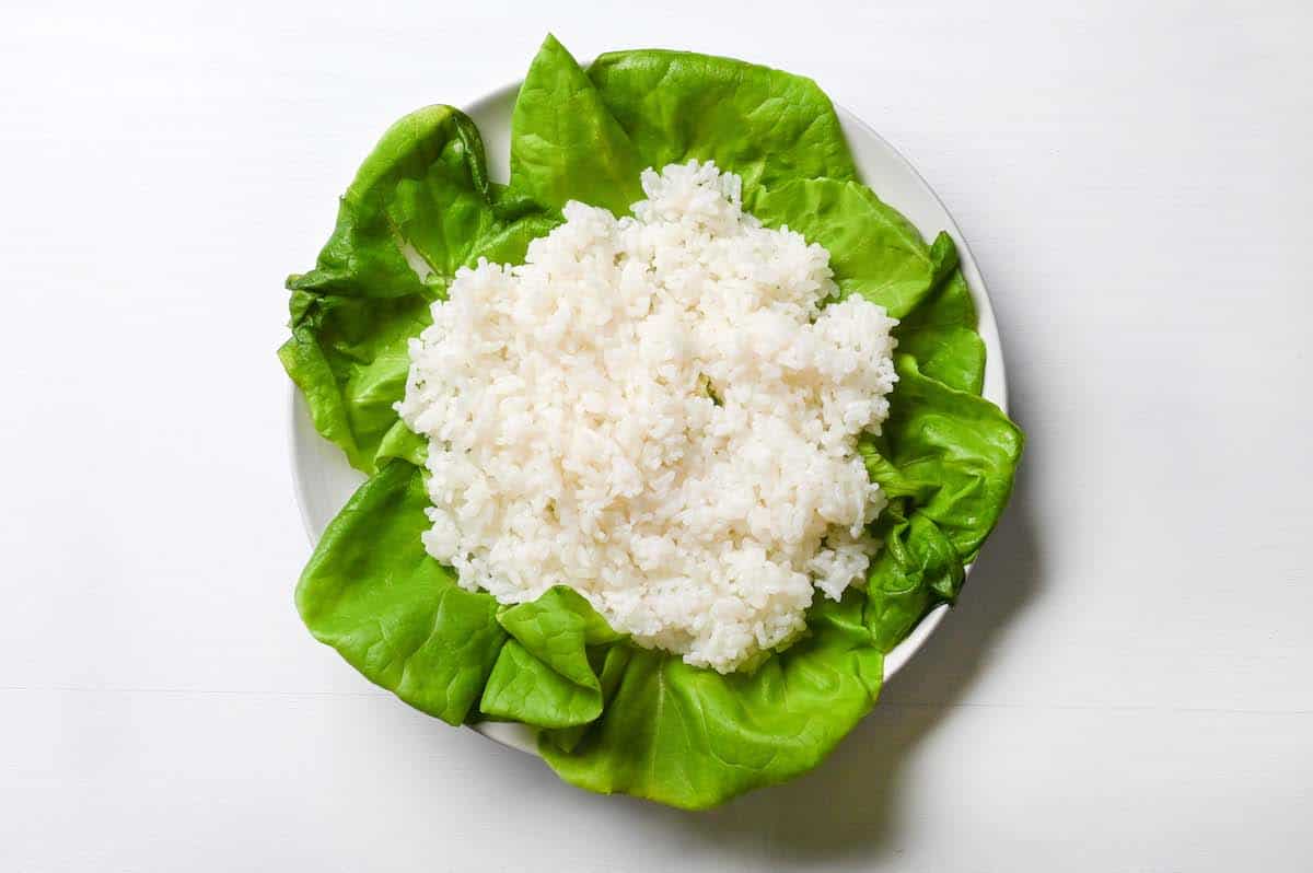 rice layered over lettuce leaves