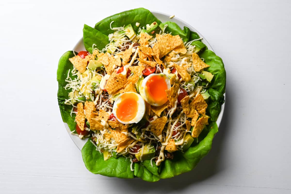 Taco rice sprinkled with cheese, mayonnaise and soft boiled eggs