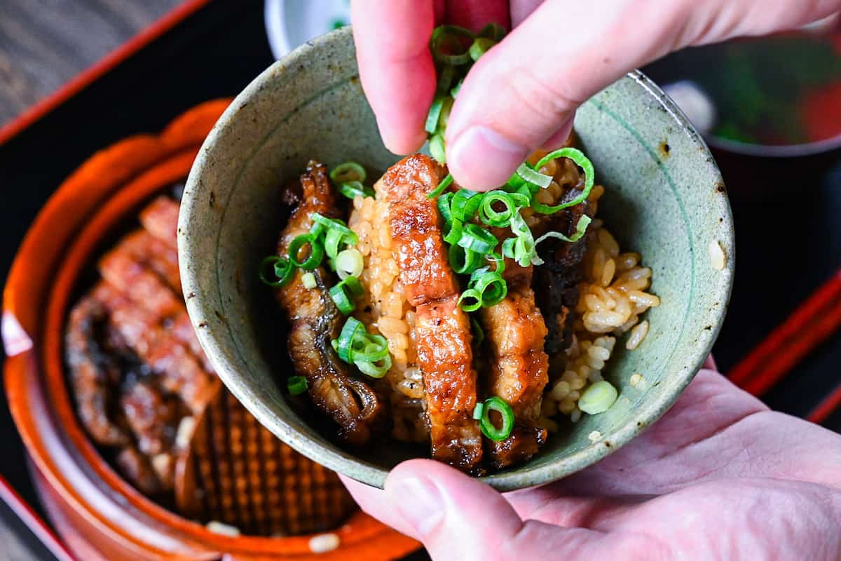 Sprinkling Hitsumabushi with chopped spring onion