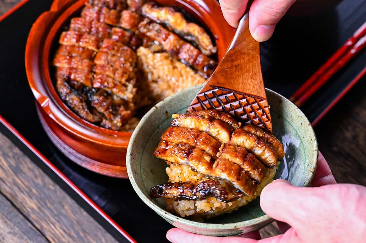 placing a portion of Hitsumabushi into a ceramic rice bowl