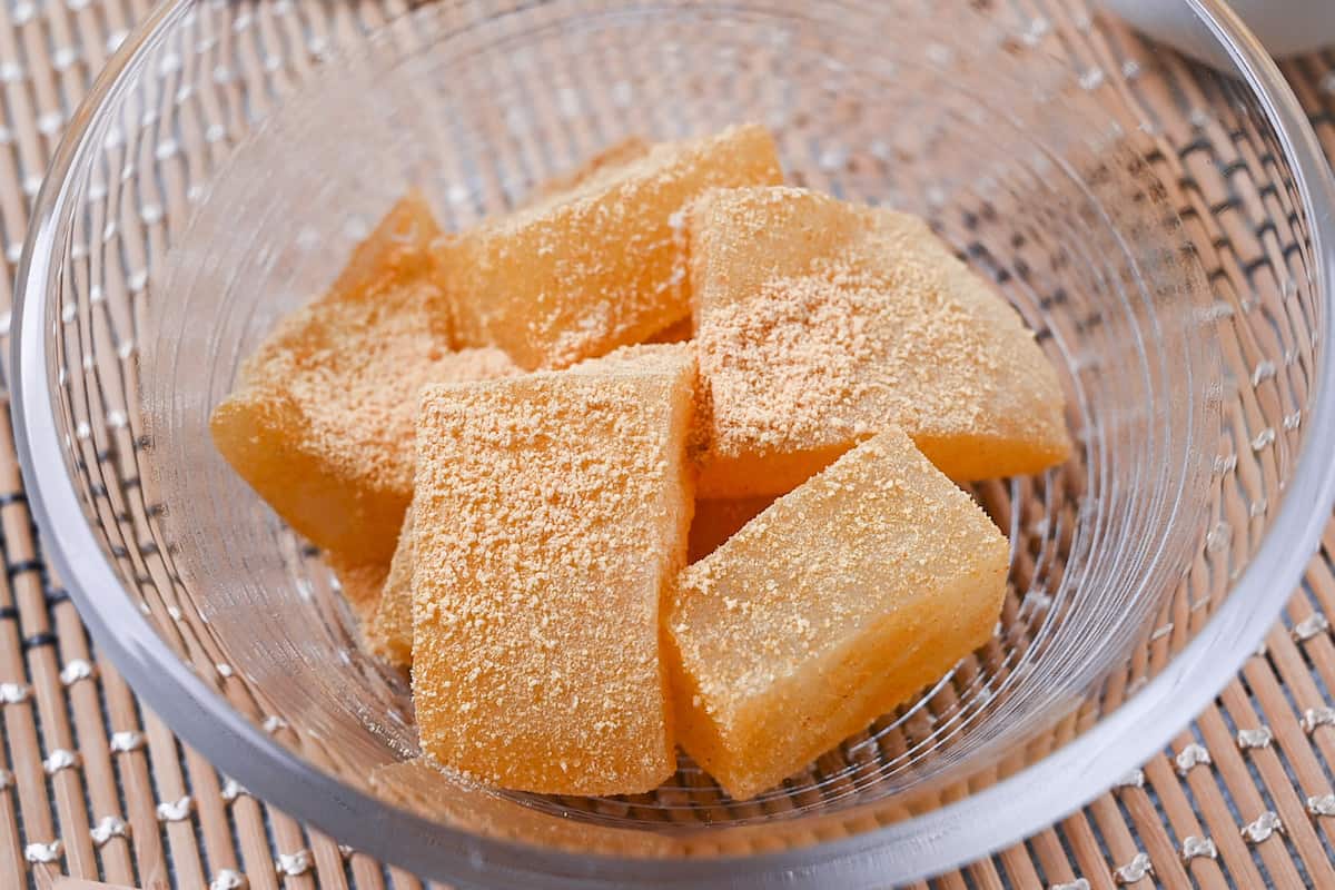 Homemade warabi mochi in a glass bowl coated with kinako roasted soy bean powder