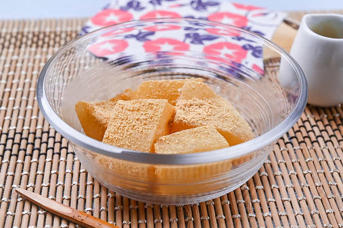 Homemade warabi mochi in a glass bowl coated with kinako roasted soy bean powder