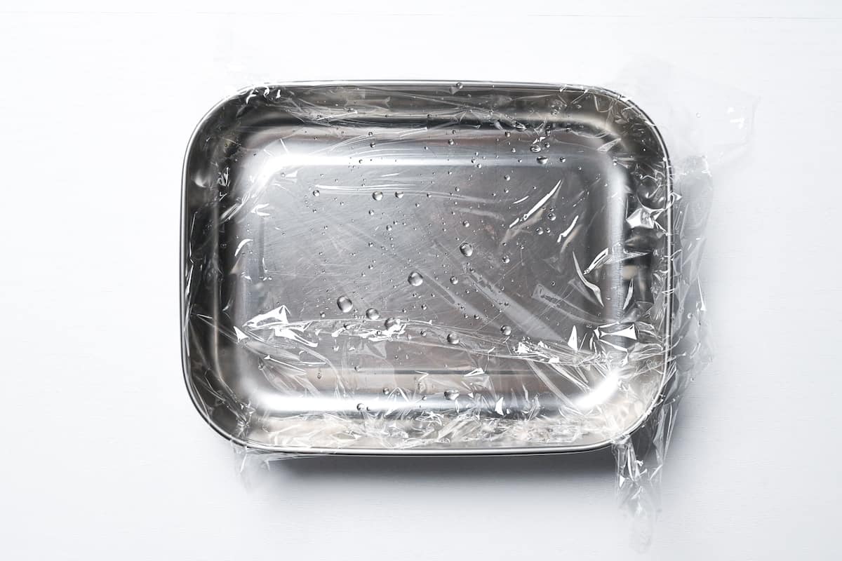 sealable container lined with plastic wrap and sprinkled with water