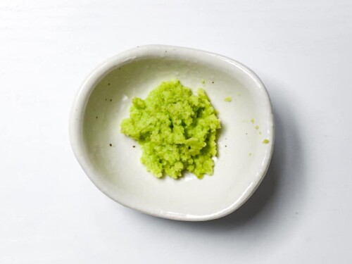 Hand ground wasabi paste in a small white bowl