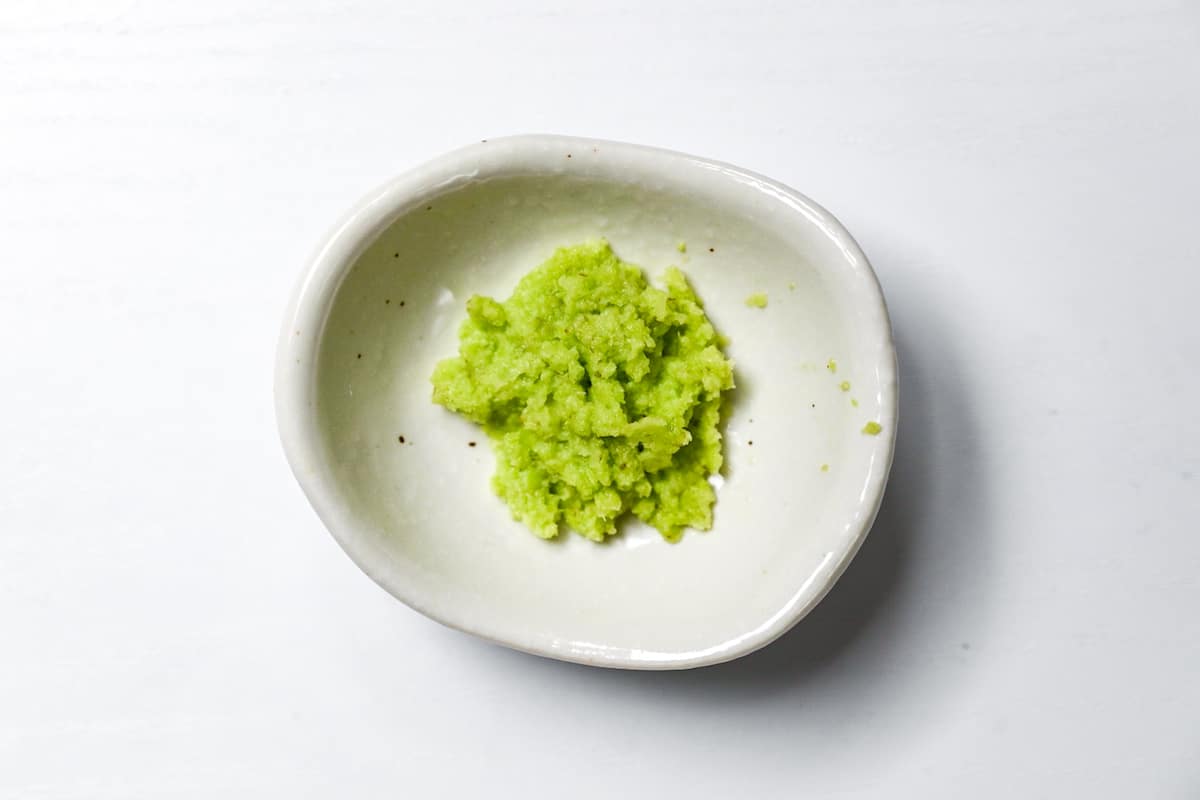 Hand ground wasabi paste in a small white bowl