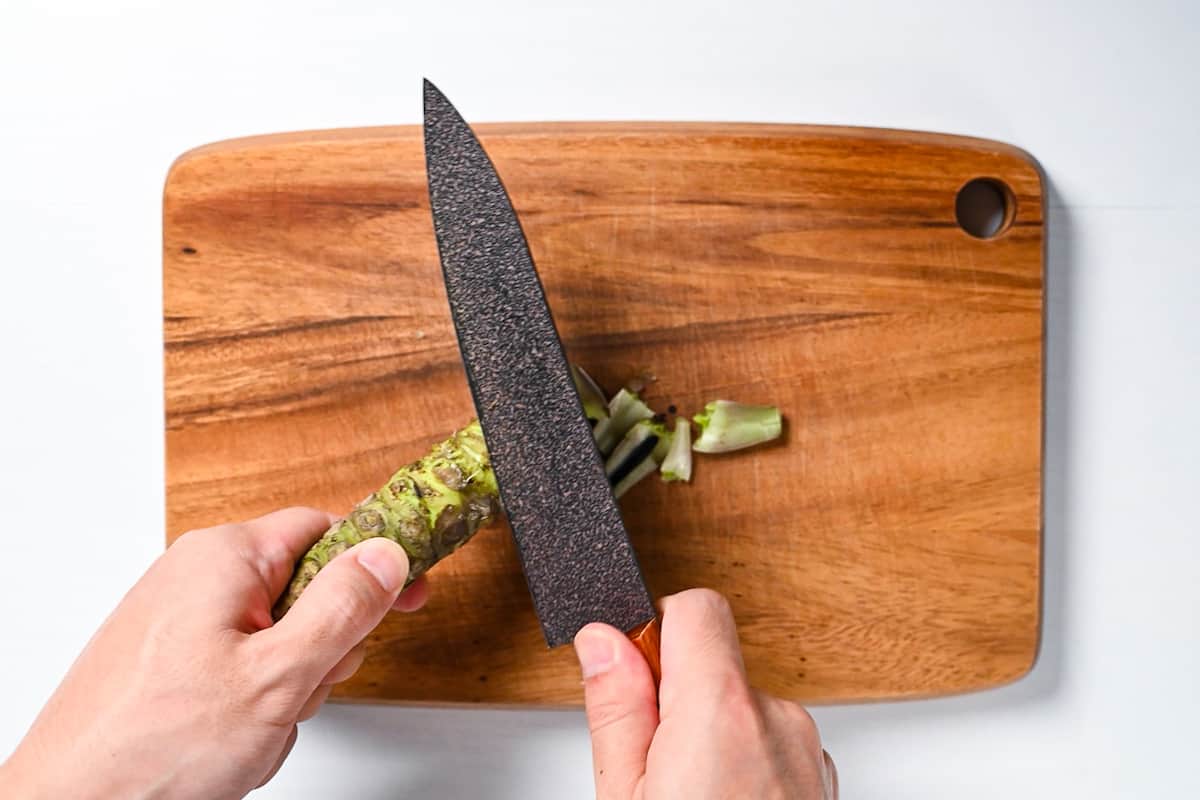 Peeling wasabi root with a knife