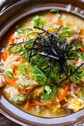 Japanese chicken rice soup (zosui / ojiya) in a brown nabe topped with kizami nori