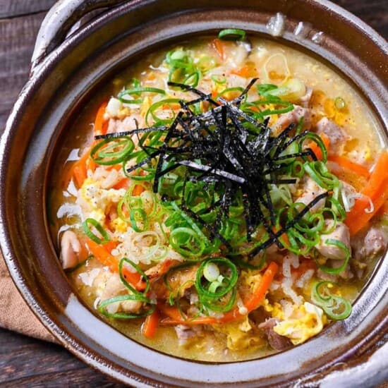 Japanese chicken rice soup (zosui / ojiya) in a brown nabe topped with kizami nori