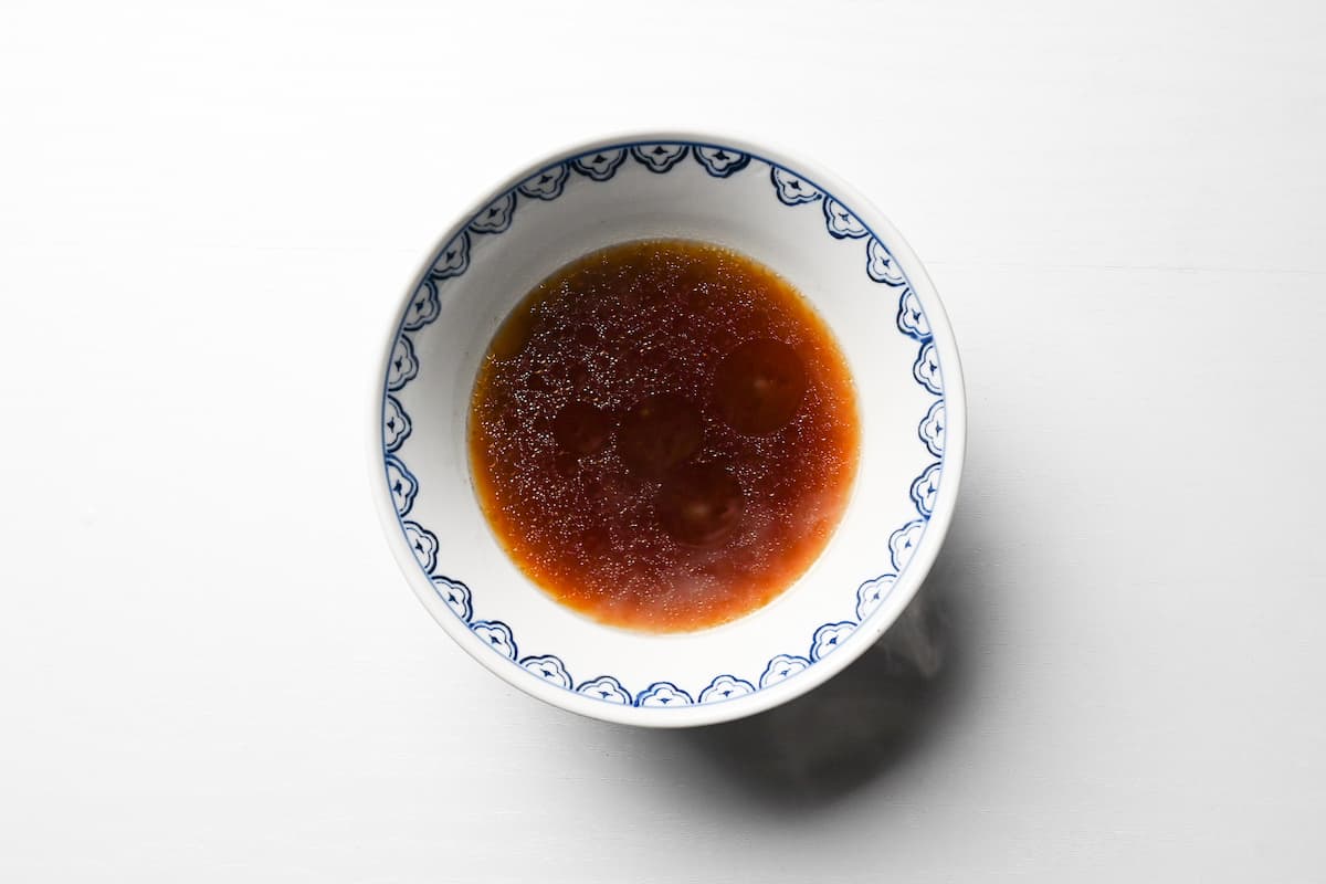 broth mixed with tare in a bowl to make shoyu ramen