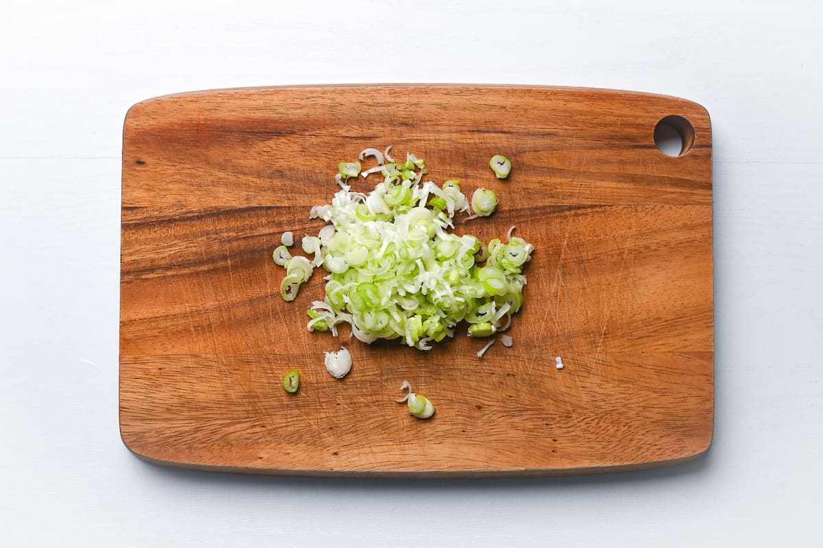 chopped spring onion on a wooden chopping board