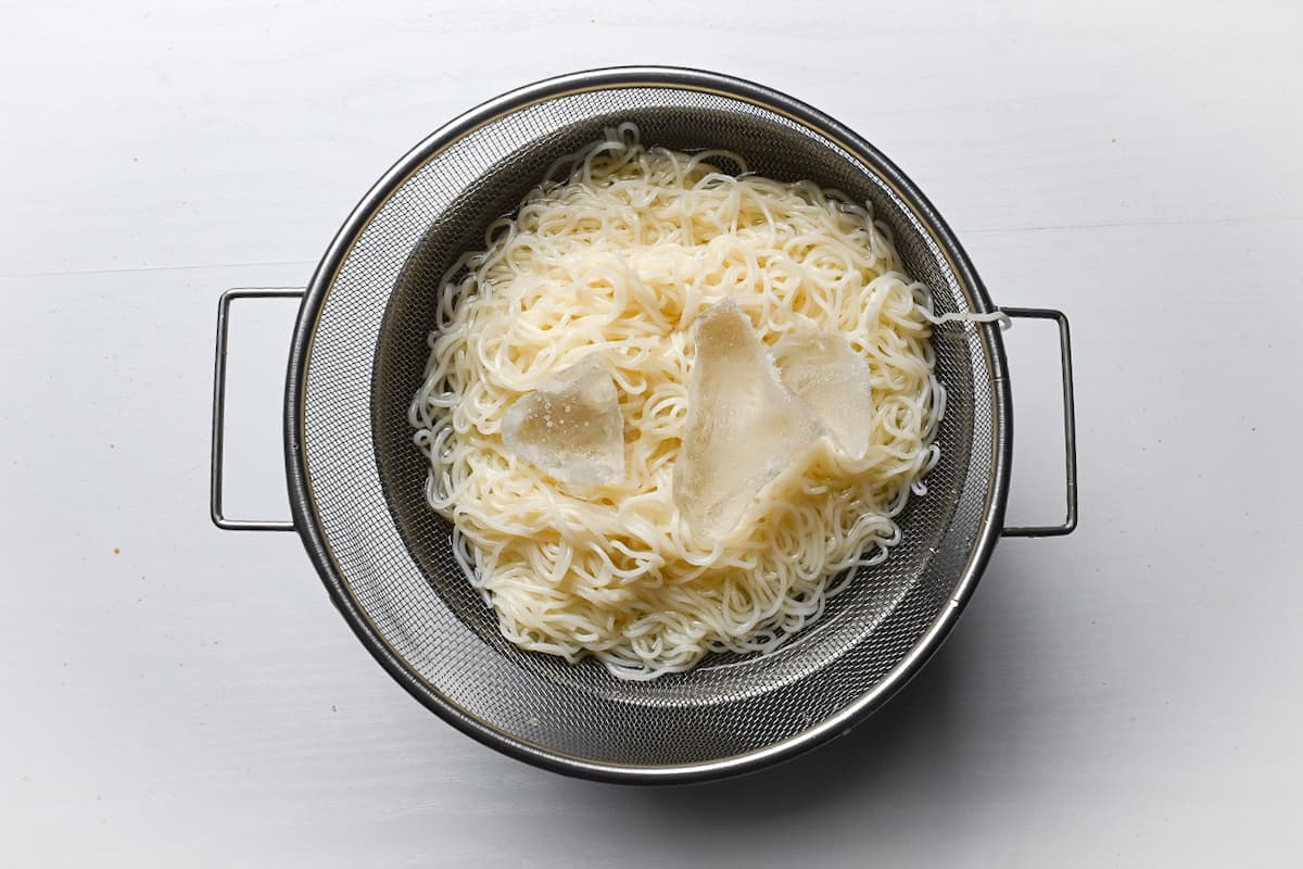 chilling somen noodles with ice in a large sieve