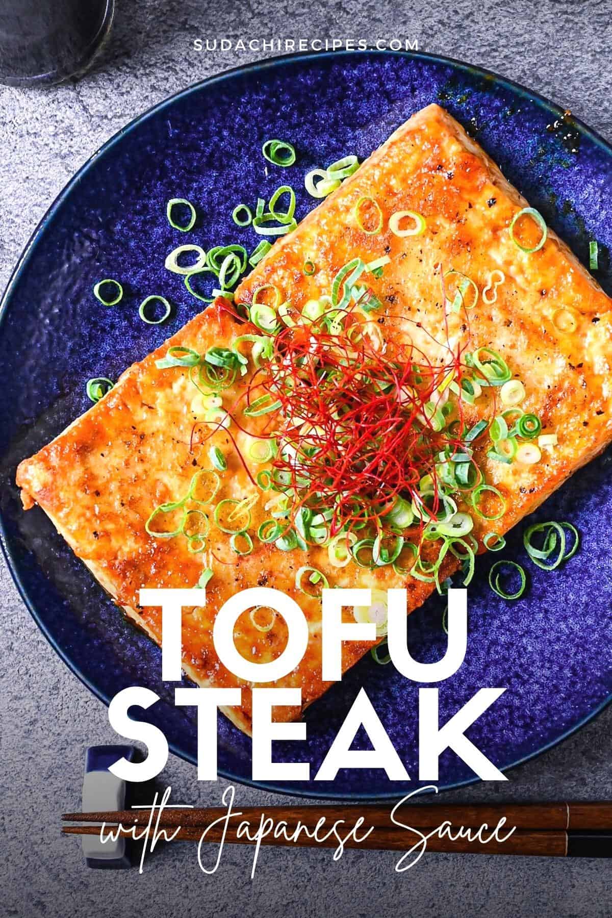 Tofu steak coated in a Japanese style sauce topped with spring onion and chili threads on a blue plate