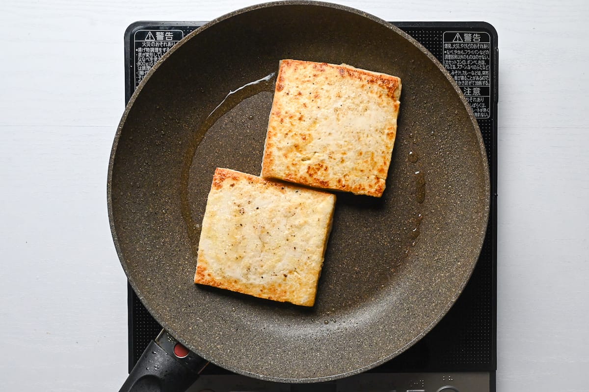 two pieces of firm tofu in a frying pan