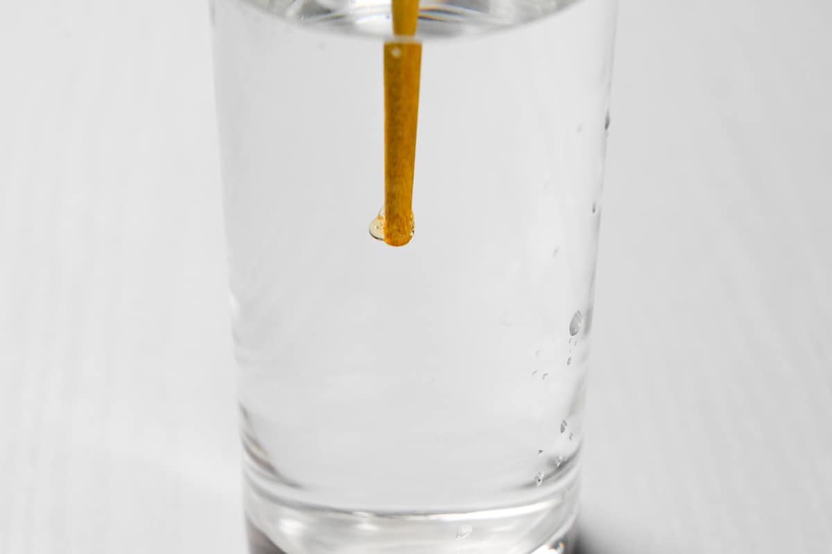 Hardened caramel on a chopstick submerged in water