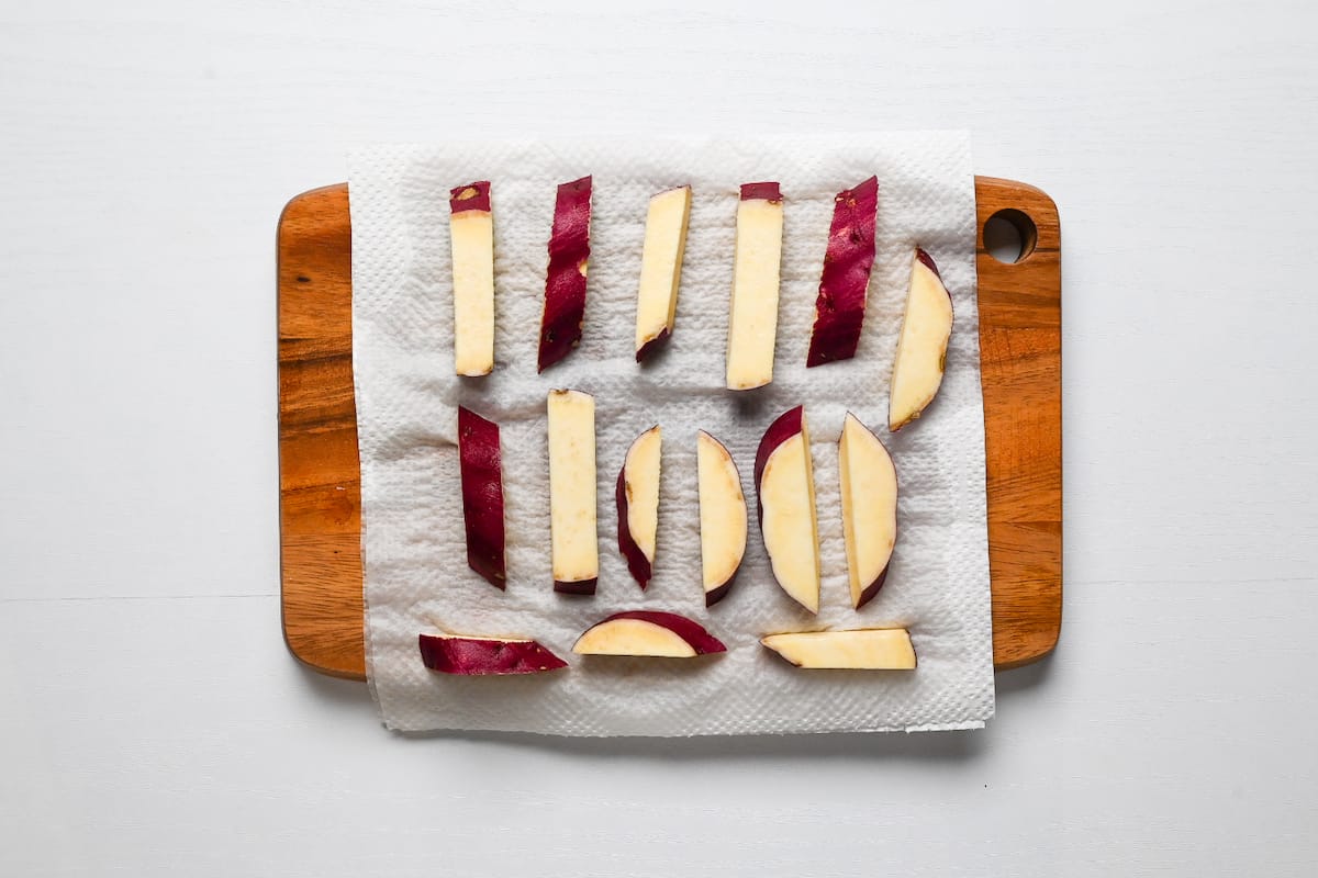 Sticks of Japanese sweet potato drying on kitchen paper