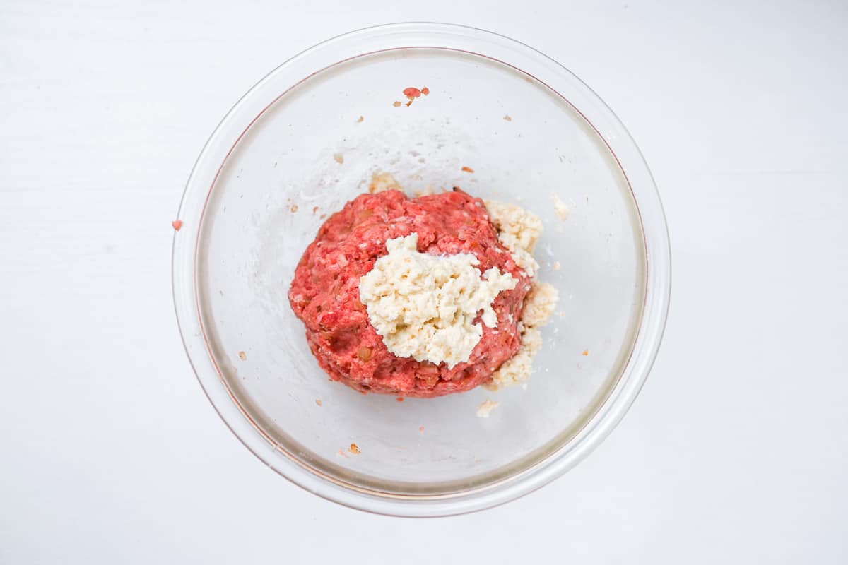 Mixing seasoned mince with soaked panko breadcrumbs