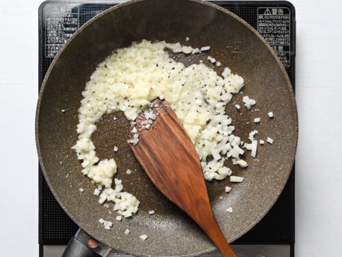 fried diced onion in a frying pan