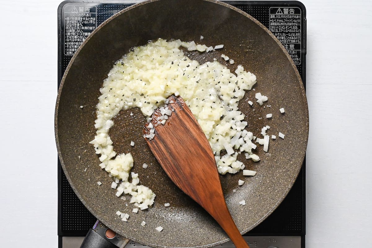 fried diced onion in a frying pan