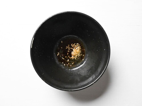 Simple tare of dashi, soy sauce and chicken stock in a black ramen bowl for Taiwan mazesoba