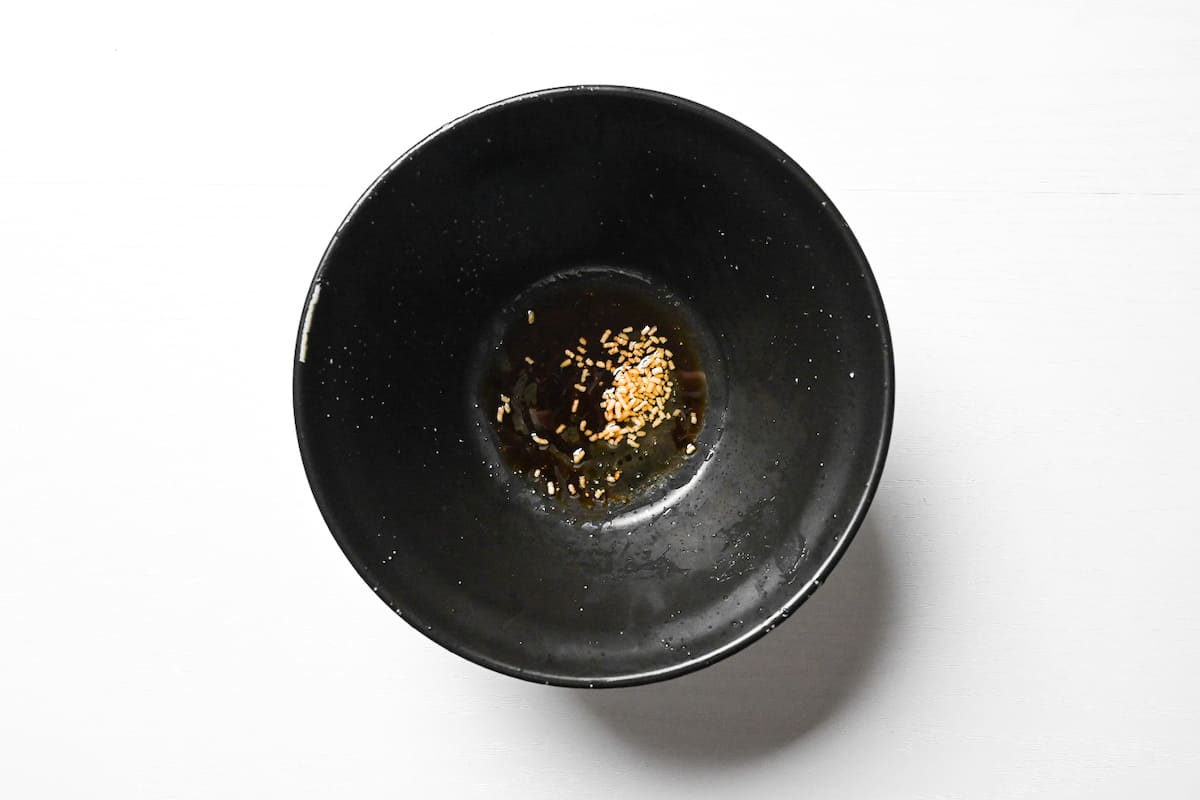 Simple tare of dashi, soy sauce and chicken stock in a black ramen bowl for Taiwan mazesoba