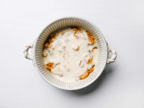 spiced seafood rice topped with bechamel sauce in an oven proof dish