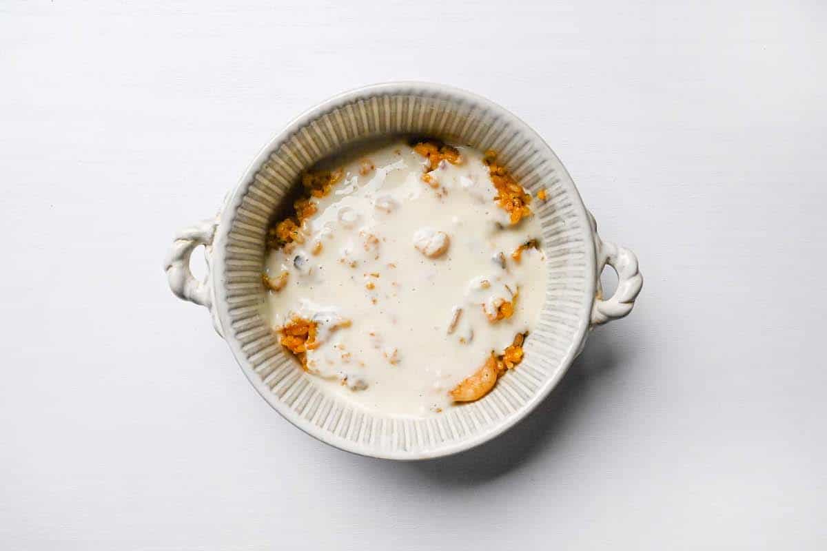 spiced seafood rice topped with bechamel sauce in an oven proof dish